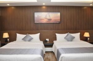 海防的住宿－An Tín Hotel，酒店客房设有两张床,墙上挂有帆船