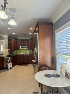 a kitchen with wooden cabinets and a table and a counter at Holiday Room with Private Bathroom in ATL, Summerhill, Stairs Required in Atlanta