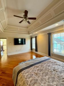 una camera da letto con ventilatore a soffitto e TV di Holiday Room with Private Bathroom in ATL, Summerhill, Stairs Required ad Atlanta