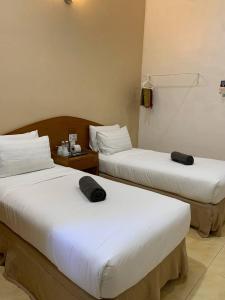 duas camas num quarto de hotel com duas em ANGGERIK IMPIAN HOTEL -Best for Travellers at Kuala Berang em Kuala Berang