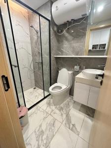 a bathroom with a toilet and a shower and a sink at Brand New Modern Luxury Studio Apartment at the Heart of Vientiane in Vientiane