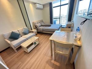 a living room with a couch and a table at Brand New Modern Luxury Studio Apartment at the Heart of Vientiane in Vientiane