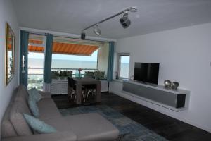 een woonkamer met een bank en een flatscreen-tv bij Berrie's Sea View in Zandvoort
