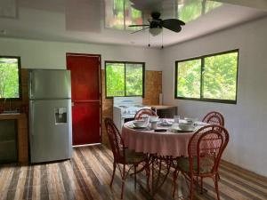 a kitchen with a table with chairs and a refrigerator at Shiozaki in Bajos del Toro