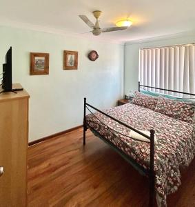 a bedroom with a bed and a ceiling fan at Geraldton Holiday Unit with free Streaming in Geraldton