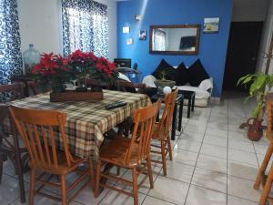 ein Esszimmer mit einem Tisch mit roten Blumen darauf in der Unterkunft Departamento centrico in San Juan del Río