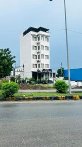 um edifício branco com um sinal em frente em Hotel Mangal Niwas em Bedla