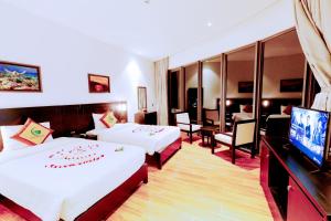 ein Hotelzimmer mit zwei Betten und einem Flachbildfernseher in der Unterkunft Ly Son Pearl Island Hotel & Resort in Ly Son