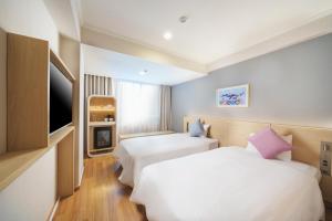 那覇市にあるOrion Hotel NAHAのベッド2台、薄型テレビが備わるホテルルームです。
