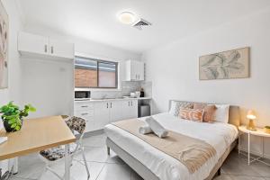 a small bedroom with a bed and a kitchen at Cozy Bankstown Stayz in Bankstown