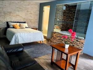 - une chambre avec un lit et un mur en briques dans l'établissement La Finca del Abuelo Teotihuacan, à San Juan Teotihuacán