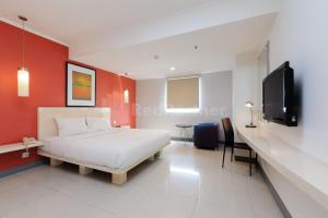 a bedroom with a bed and a flat screen tv at NamRoom Hotel Glodok RedPartner in Jakarta