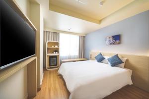 a hotel room with a bed and a flat screen tv at 琉球オリオンホテル 那覇国際通り in Naha