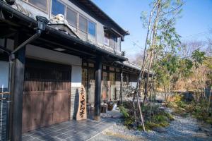 una casa asiática con una puerta y un edificio en お宿でん吉 en Minami Aso
