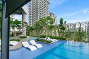 八打灵再也Highpark Suites at Petaling Jaya, Kelana Jaya by Plush的一座带白色椅子的游泳池和一座建筑
