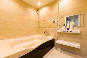 a bathroom with a tub and a sink at Himalaya Cloud Hotel in Tokyo