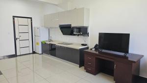 a small kitchen with a desk and a television at Prince Studio Apartments in Willemstad