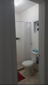 ein Badezimmer mit einem weißen WC und einer Dusche in der Unterkunft Areia Branca Casas / casa 1. in Cabo Frio