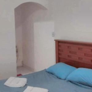 Schlafzimmer mit einem blauen Bett und einem Kopfteil aus Holz in der Unterkunft Areia Branca Casas / casa 1. in Cabo Frio