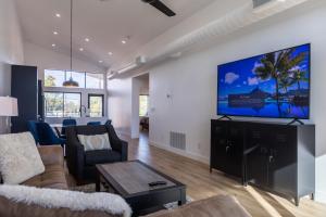 sala de estar con TV de pantalla plana grande en la pared en Modern Downtown Phoenix Condo Near Hance Park en Phoenix
