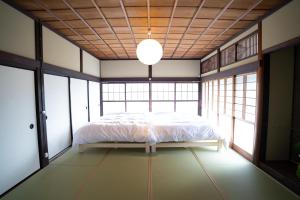 a bedroom with a bed in a room with windows at citrus house in Wakayama
