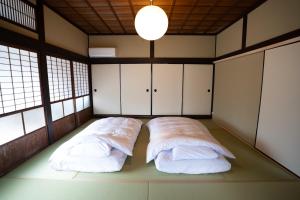 2 letti in una camera con armadi bianchi di citrus house a Wakayama