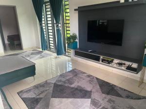 uma sala de estar com uma televisão de ecrã plano na parede em Creatills luxury homestay Kulim & hi-tech em Kulim