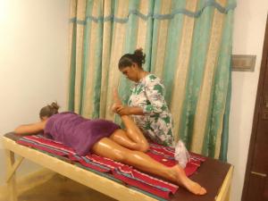 a woman sitting on a bed with a girl at Wallama Villa in Ambalangoda