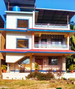um grande edifício branco com uma varanda em Bhakti holiday home em Revadanda