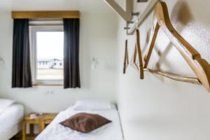 Cette chambre comprend un lit et une fenêtre. dans l'établissement Vogahraun 4, à Mývatn
