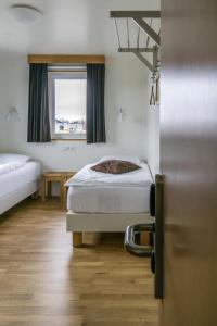 een ziekenhuiskamer met 2 bedden en een raam bij Vogahraun 4 in Myvatn