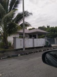 uma casa com uma cerca branca e uma palmeira em Creatills luxury homestay Kulim & hi-tech em Kulim