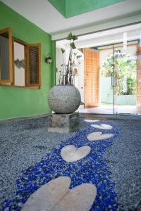 una hall con un vaso sul pavimento con fiori blu di Barefoot Bungalow Hikka a Hikkaduwa