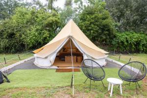 a tent with two chairs and a table and chairs at Coonamble Riverside Caravan Park in Coonamble