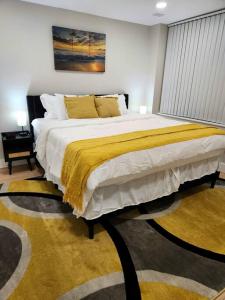 a bedroom with a large bed with a yellow blanket at *The Stunning *King Suite* Heart of Towson in Towson