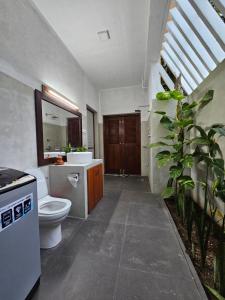 un baño con inodoro y lavabo en Syndeo Garden, en Hikkaduwa 21 fotos más