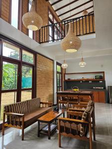 sala de estar con bancos, mesas y ventanas en Syndeo Garden, en Hikkaduwa