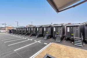 eine Reihe tragbarer Toiletten auf einem Parkplatz in der Unterkunft HOTEL R9 The Yard 唐津 in Karatsu