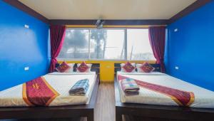 Cette chambre comprend 2 lits dans une chambre dotée de murs bleus et d'une fenêtre. dans l'établissement Đại Nam Hotel - số 07 ngõ 47 phố Fansipan - by Bay Luxury, à Sa Pa 13 autres photos