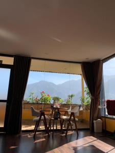 une salle à manger avec une table et des chaises et une grande fenêtre dans l'établissement Đại Nam Hotel - số 07 ngõ 47 phố Fansipan - by Bay Luxury, à Sa Pa
