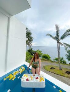 Eine Frau im Bikini, die im Pool sitzt. in der Unterkunft Bintana Sa Paraiso in Mambajao