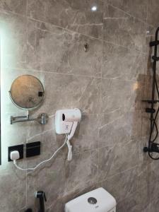 ein Badezimmer mit einem weißen WC und einem Spiegel in der Unterkunft قمة راحتي للشقق المخدومة Qimat Rahaity SERVICED APARTMENTS in Yanbu