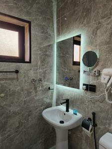 a bathroom with a sink and a mirror at قمة راحتي للشقق المخدومة Qimat Rahaity SERVICED APARTMENTS in Yanbu