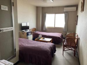 函館市にあるホテル テトラ 湯の川温泉のベッド2台と窓が備わるホテルルームです。