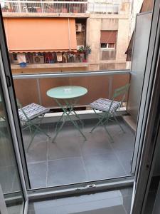 uma varanda com uma mesa e 2 cadeiras e uma janela em P.S. Attiki em Atenas