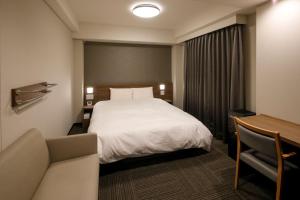 丰桥市Dormy Inn Express Toyohashi的配有床和书桌的酒店房间