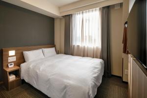 Dormy Inn Express Toyohashi客房内的一张或多张床位