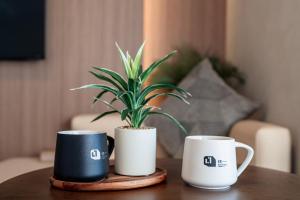 Deux tasses à café et une plante en pot sur une table dans l'établissement Apartment Hotel 11 Kuromon II, à Osaka