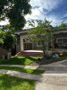 a house with a porch and a yard with grass at Payes Home in Siguatepeque