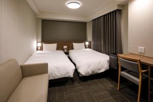 Dormy Inn Express Toyohashi客房内的一张或多张床位